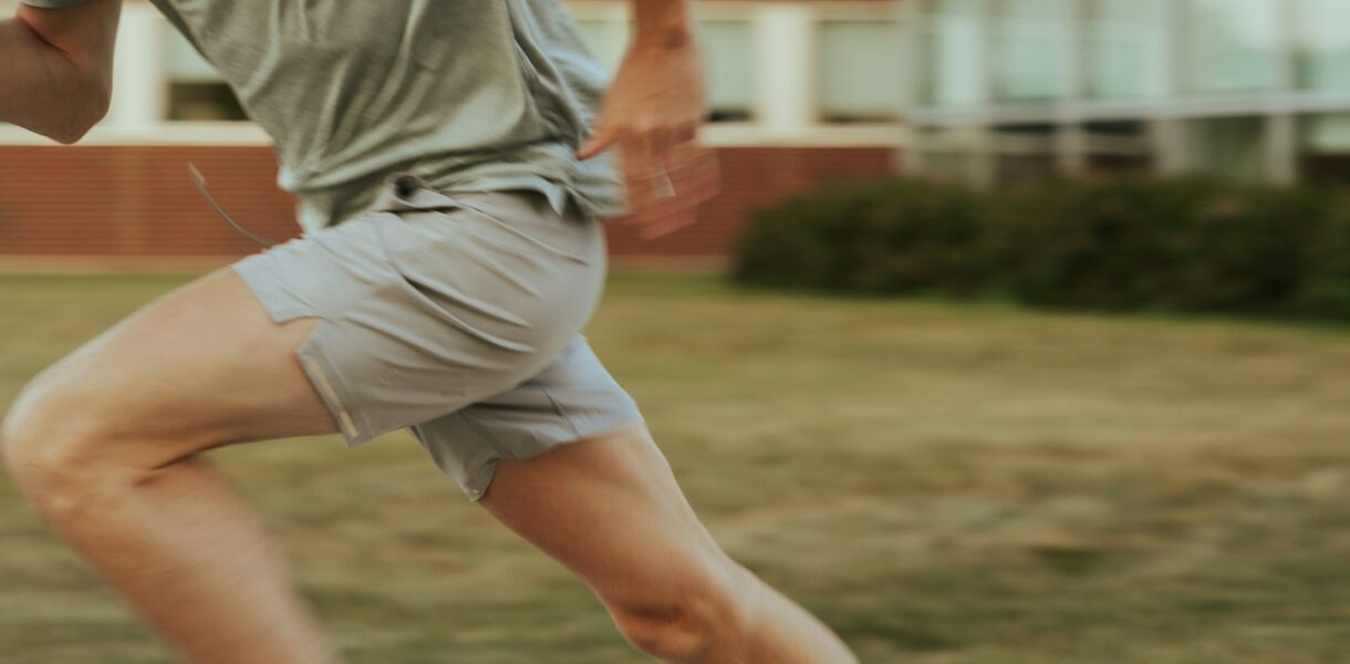 Close-up of a person sprinting outdoors, representing cardio exercise before strength training