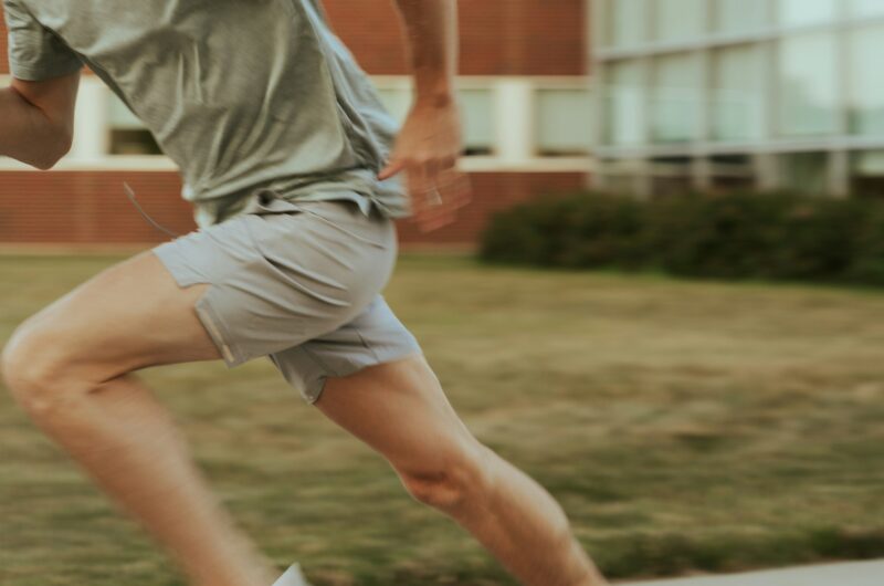 Close-up of a person sprinting outdoors, representing cardio exercise before strength training