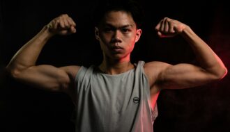 Young man flexing his muscles post-workout, highlighting strength and recovery after intense training.