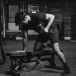 Man doing one-arm dumbbell row in gym as part of a strength training routine