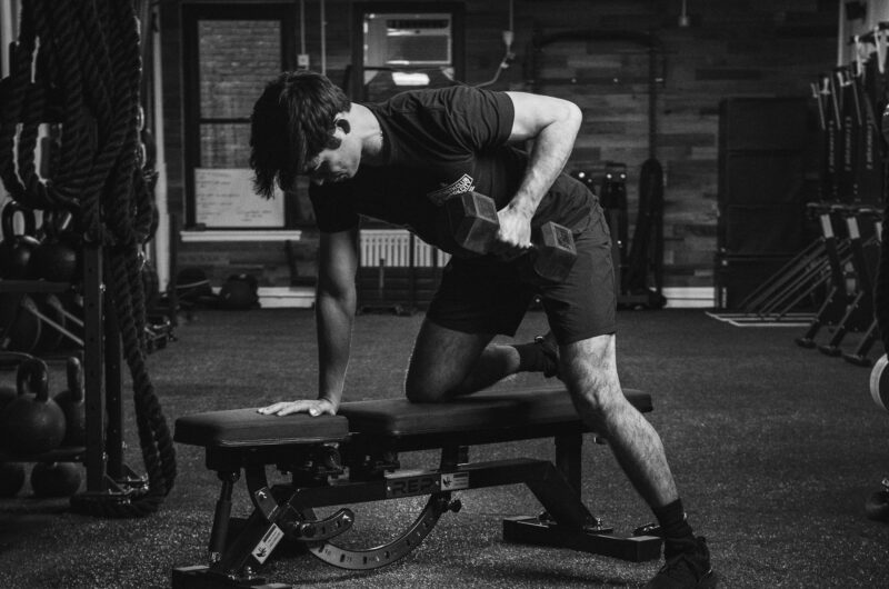 Man doing one-arm dumbbell row in gym as part of a strength training routine